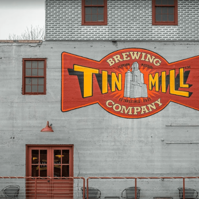 Mural of the Tin Mill Brewing Company on a grey building featuring red trim and a sign established in 2005.