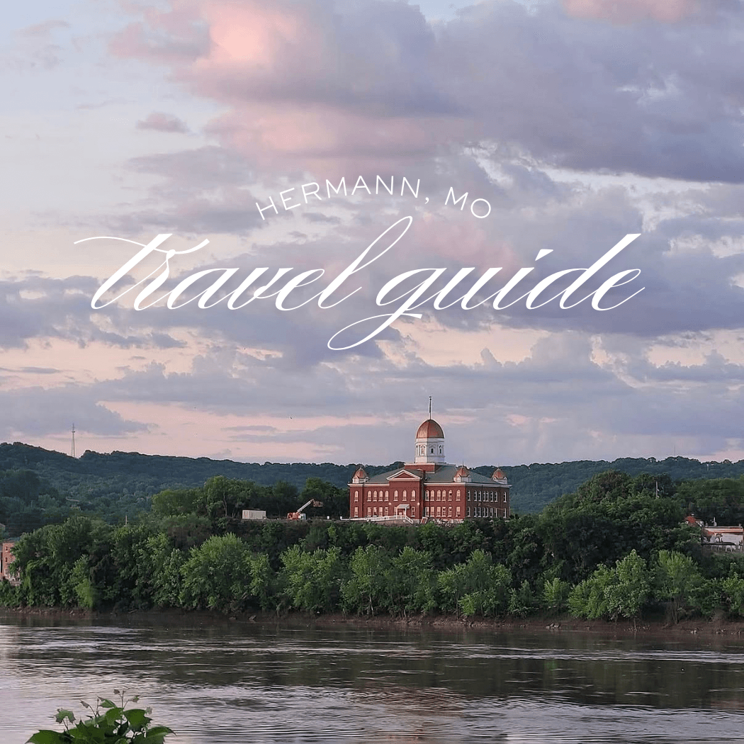 A scenic view of Hermann, Missouri, featuring a historic building beside the river against a backdrop of clouds. A scenic view of Hermann, Missouri, featuring a historic building beside the river against a backdrop of clouds.