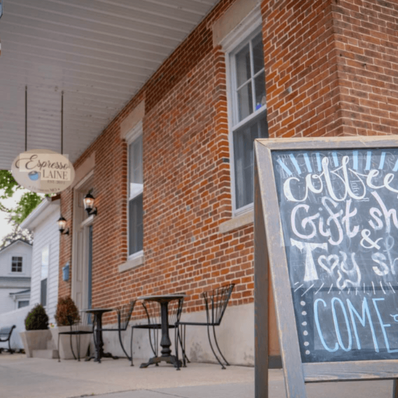 Exterior of a brick building with a sign advertising coffee and a gift shop.